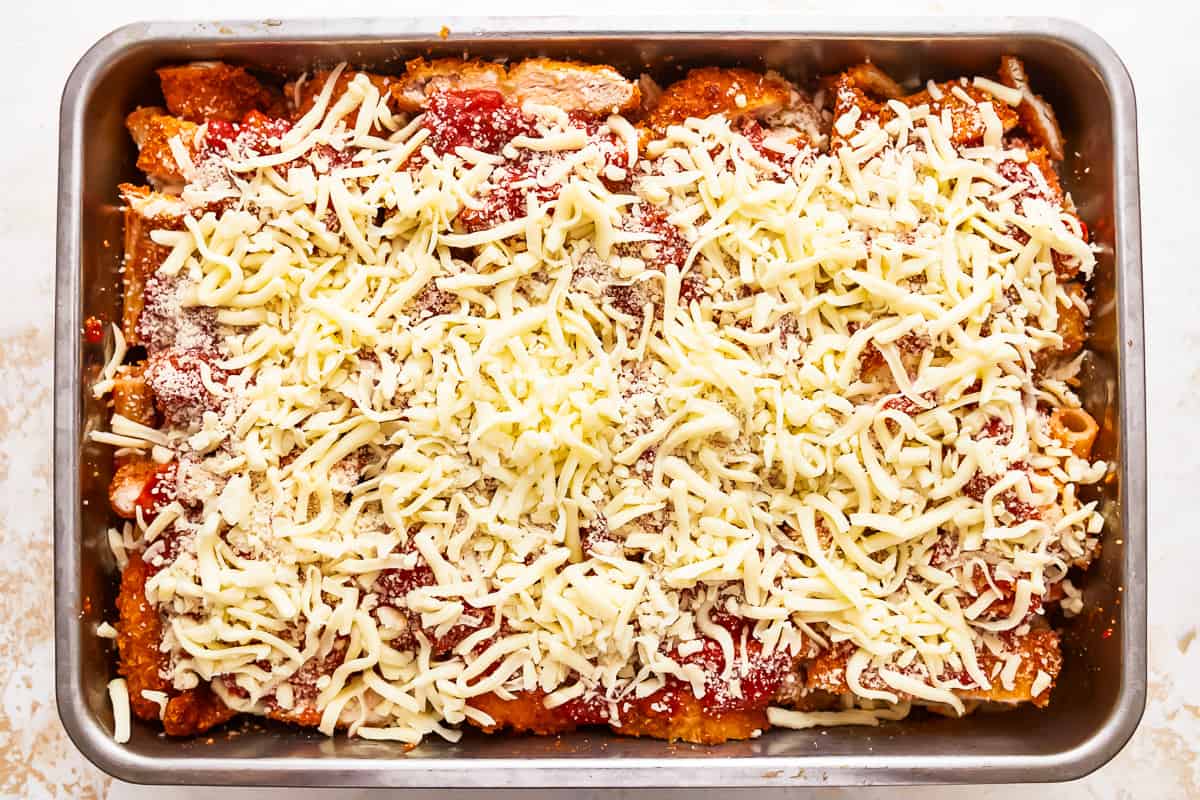 Enchiladas in a baking dish with cheese on top.