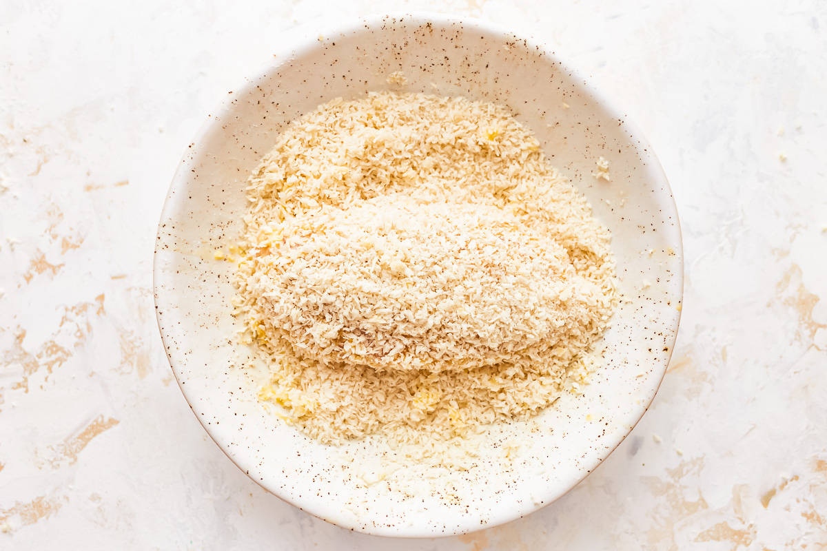 A white bowl filled with granulated sugar.