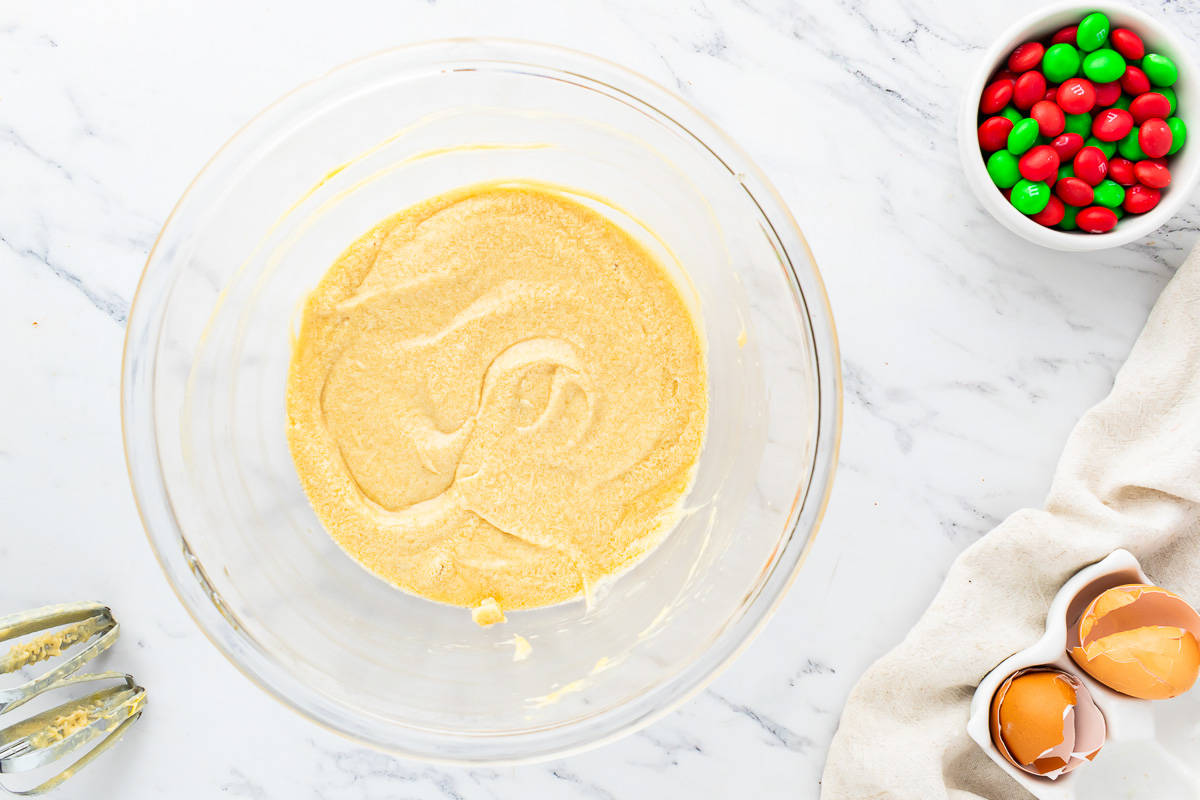 A bowl of batter with ingredients on a marble table.