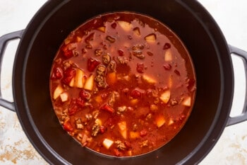 Chili in a black pot on a white background.