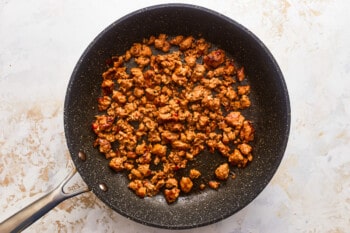 A frying pan with meat in it.