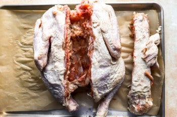 A roasted chicken on a baking sheet.