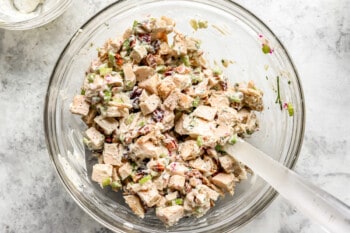 Chicken salad in a glass bowl with cranberries.