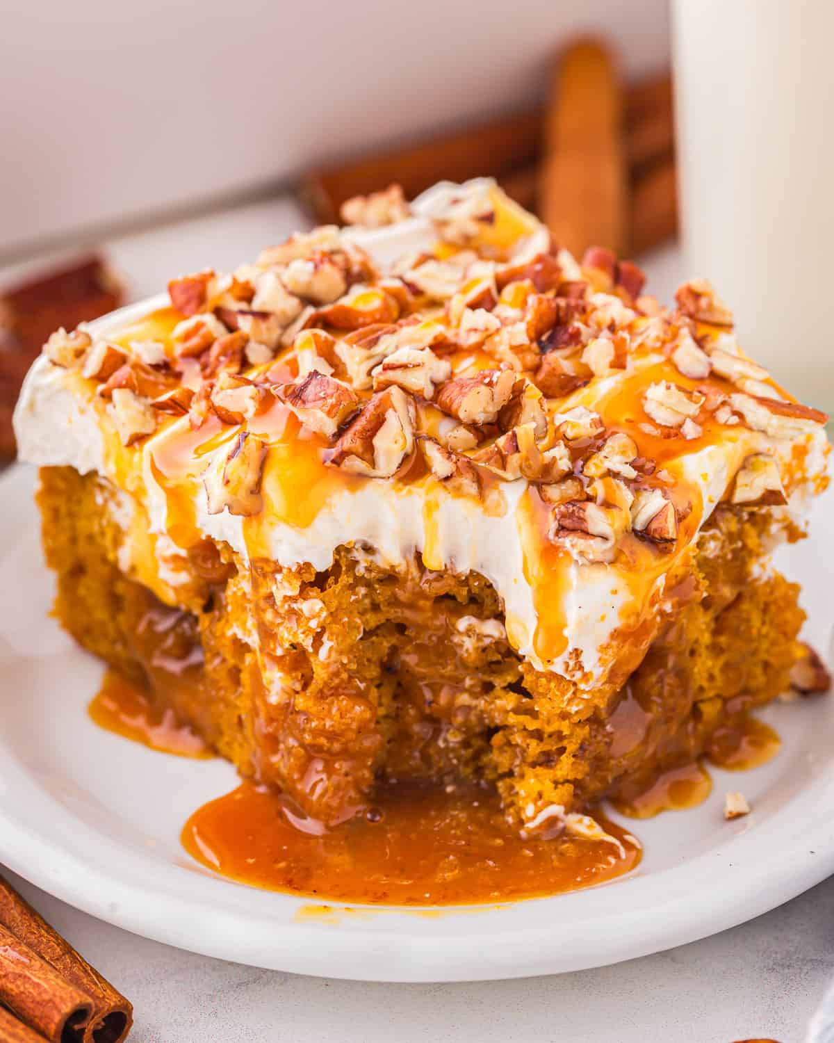 A piece of caramel pumpkin poke cake on a plate.