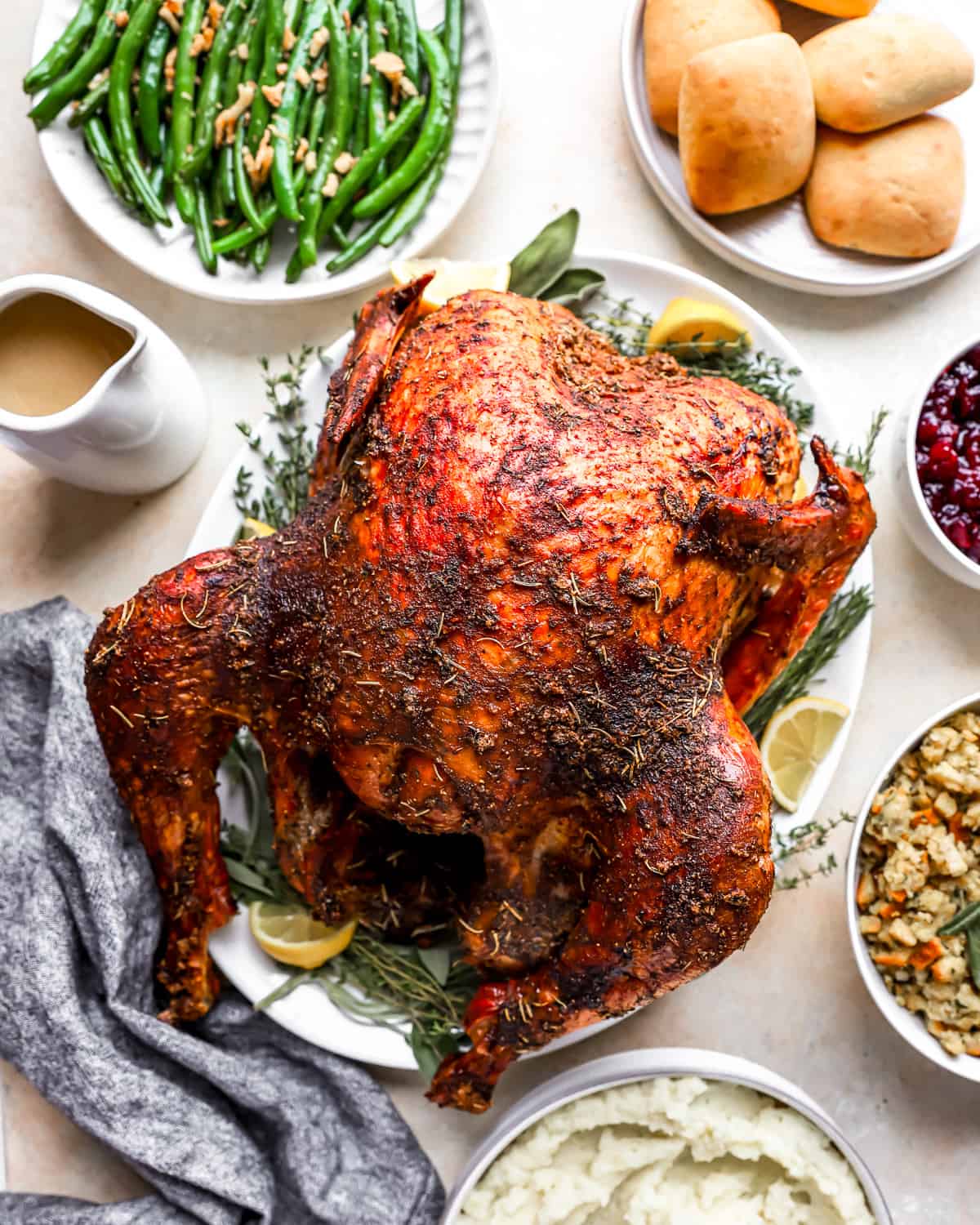 Thanksgiving dinner with a smoked turkey, green beans, mashed potatoes and cranberry sauce.