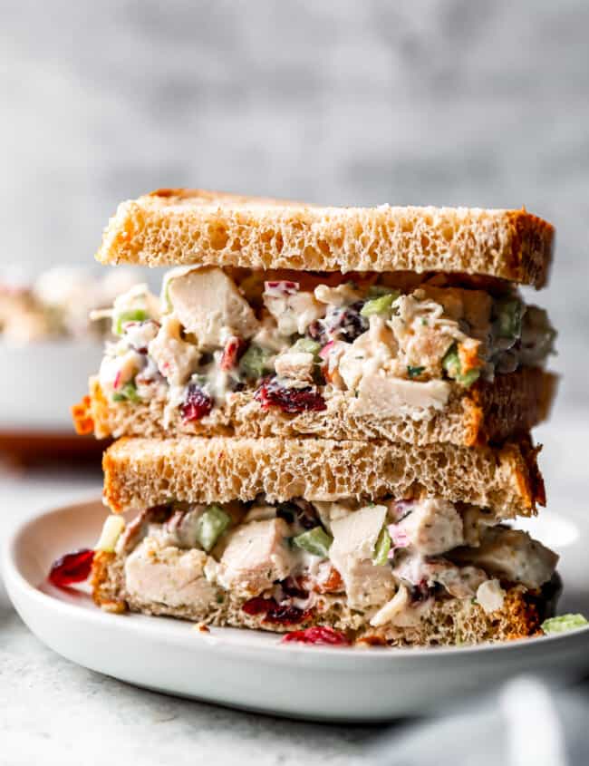 A stack of turkey salad sandwiches on a plate.