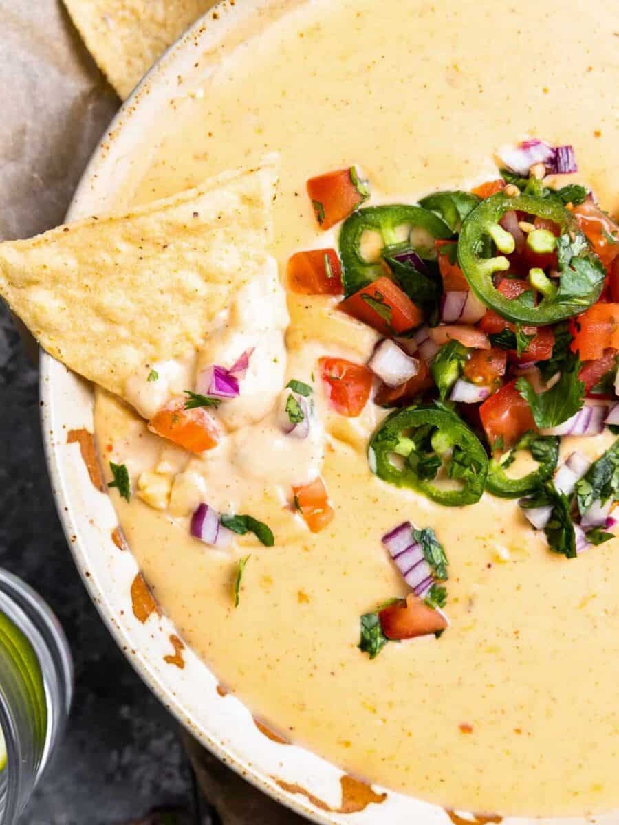 a bowl of mexican dip with chips and salsa.