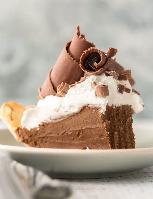 A slice of French silk pie on a white plate.