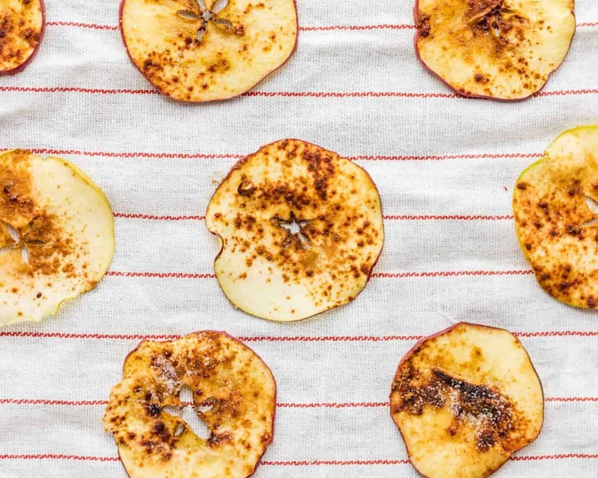 Microwave apple chips on a striped towel.