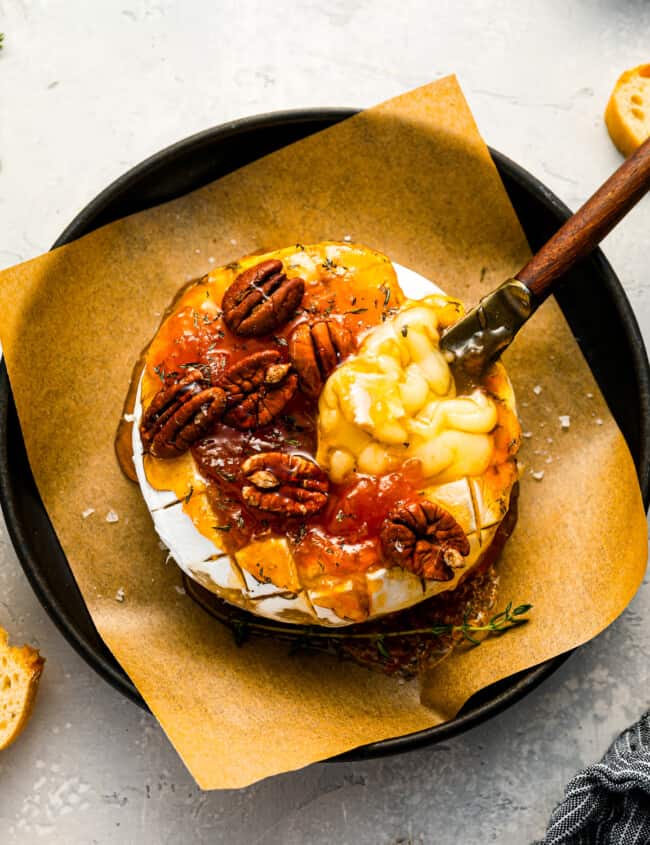 A plate with cheese and pecans on it.