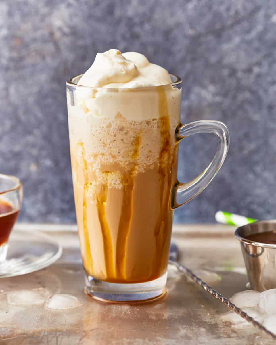 A cup of coffee with whipped cream and caramel.