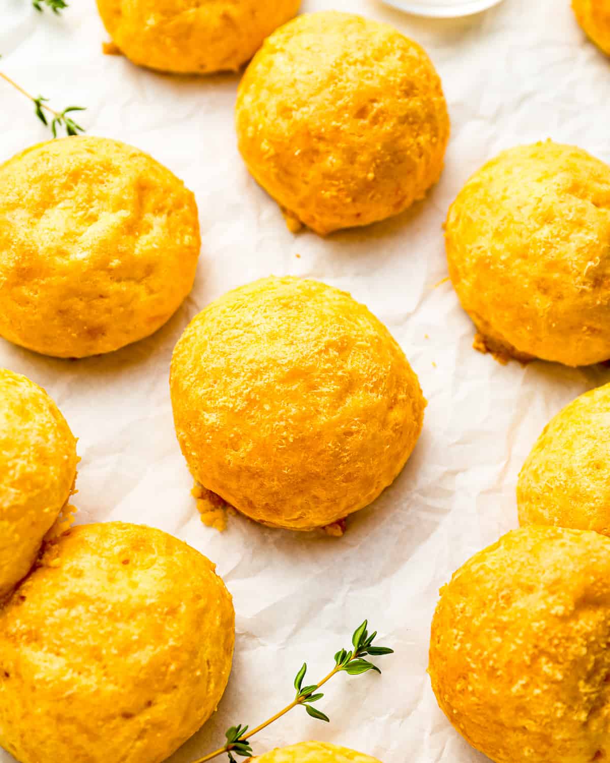 gougeres on parchment paper with thyme.