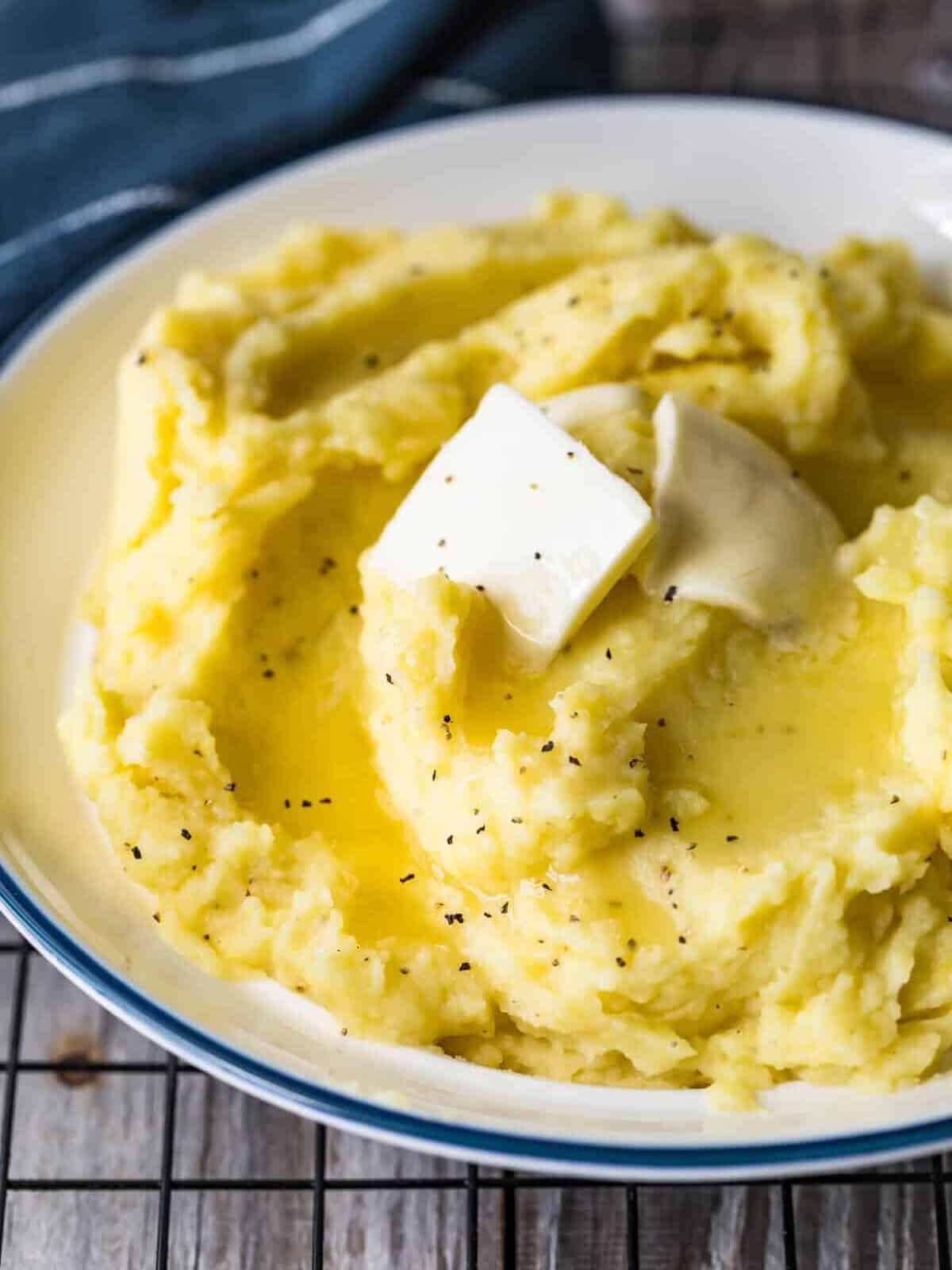 Close up of butter melting mashed potatoes in a bowl.