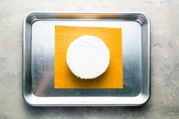 A piece of cheese on a baking sheet.