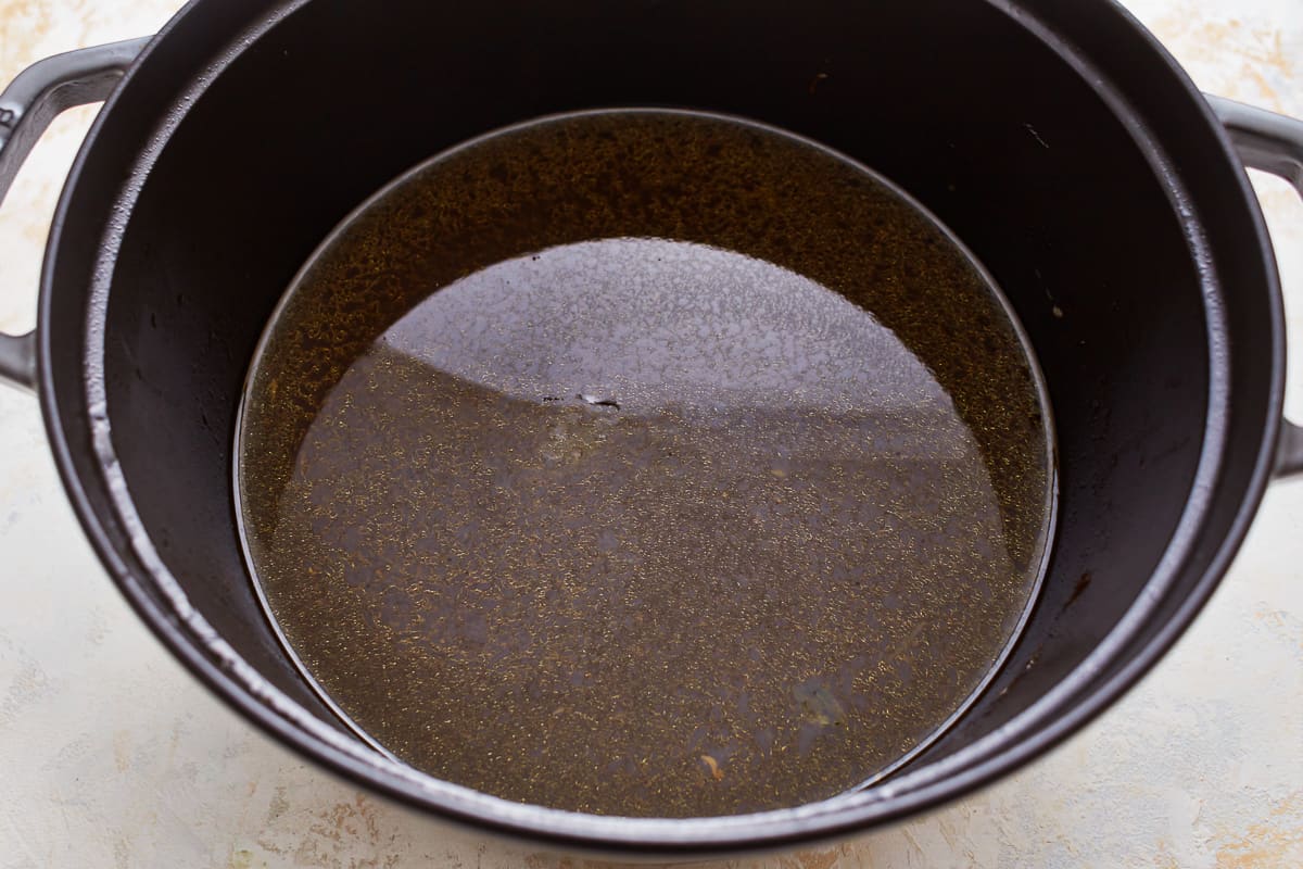 A pot filled with brown liquid on a table.