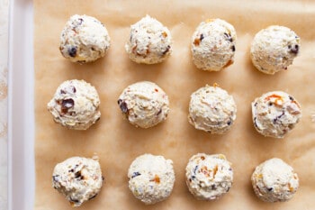 Mini cheese balls lined up on a baking sheet.