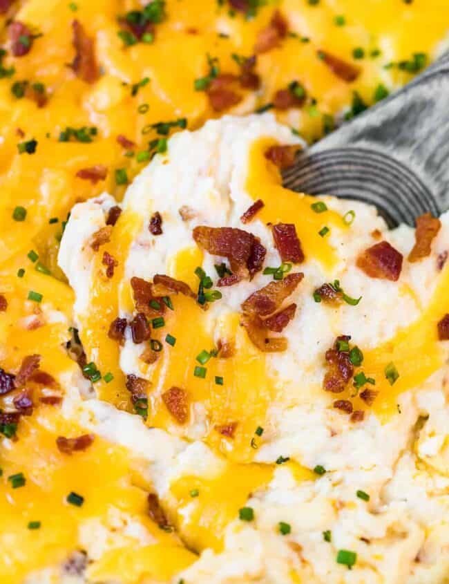 spoon digging into loaded mashed potato casserole