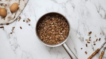 A classic Pecan Pie with nuts on a marble countertop.