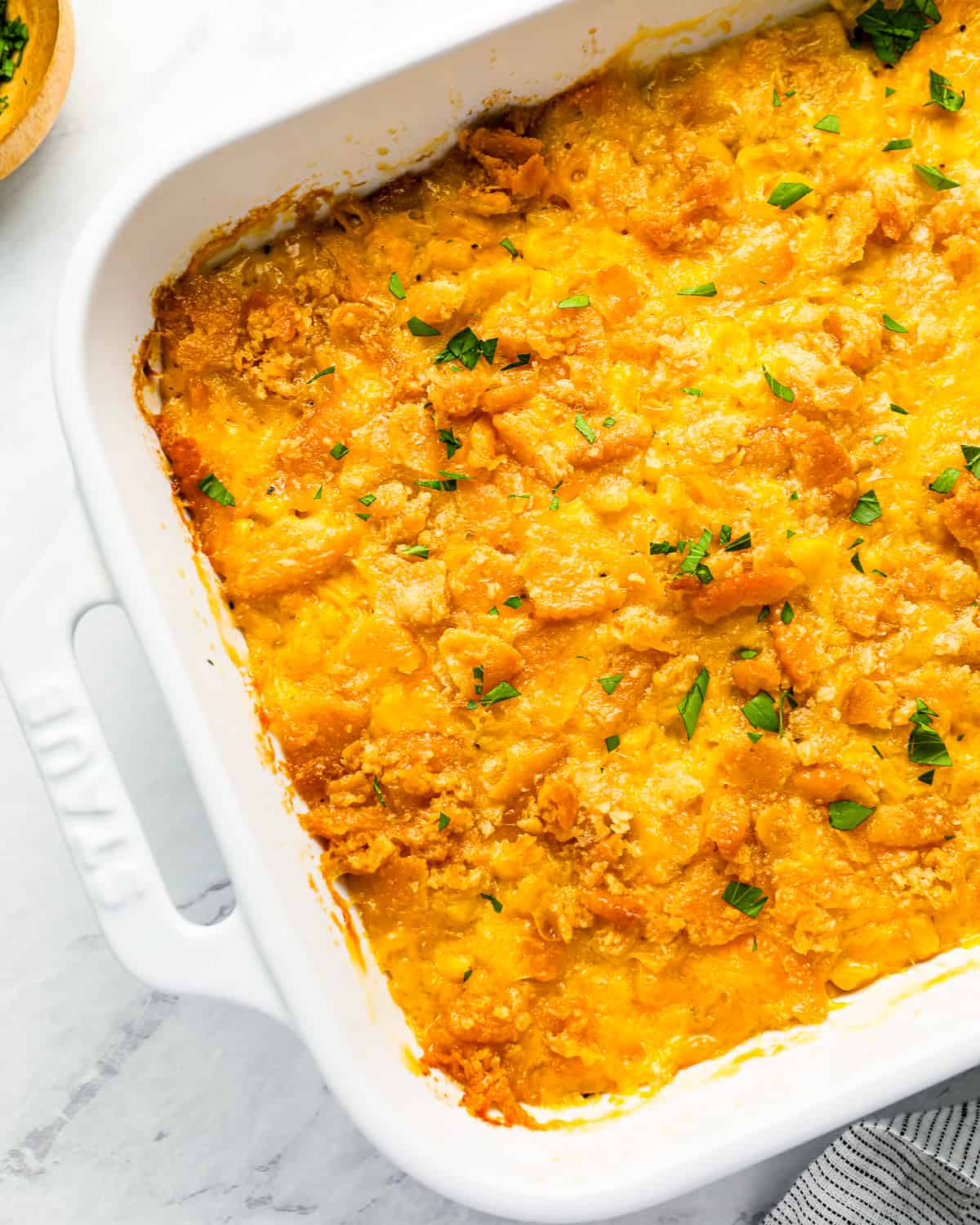 Close up on scalloped corn with cheese and cracker topping.