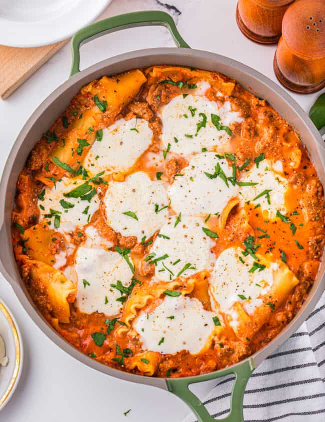 Lasagna in a pan with parmesan cheese on top.