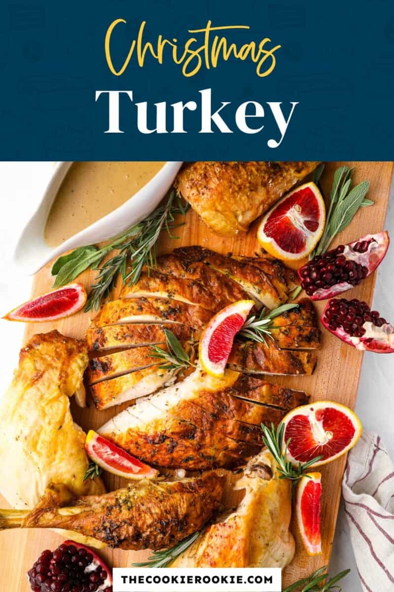 A christmas turkey on a cutting board with oranges and rosemary.