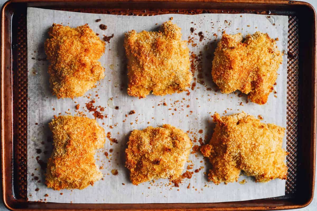 chicken thighs on a parchment paper lined baking sheet after baking