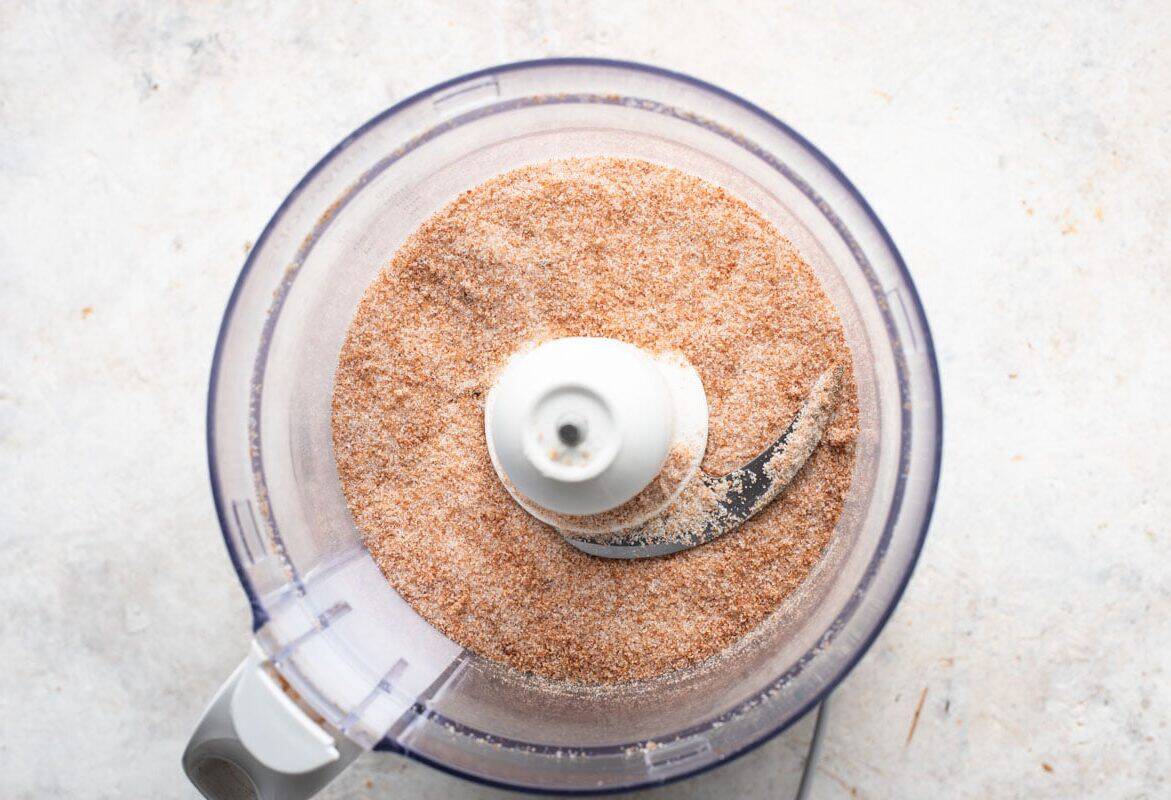 a food processor filled with brown sugar and popcorn.