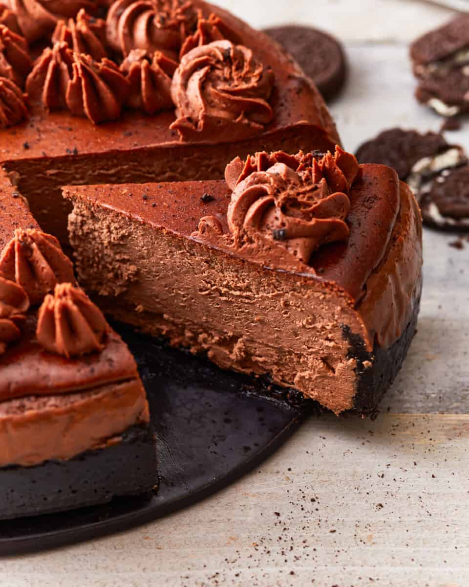 A chocolate cheesecake with a slice taken out.