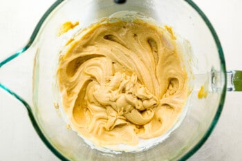 A glass bowl filled with a yellow batter.