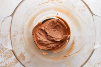 Chocolate frosting in a glass bowl.