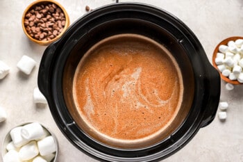 A crock pot filled with hot chocolate and marshmallows.