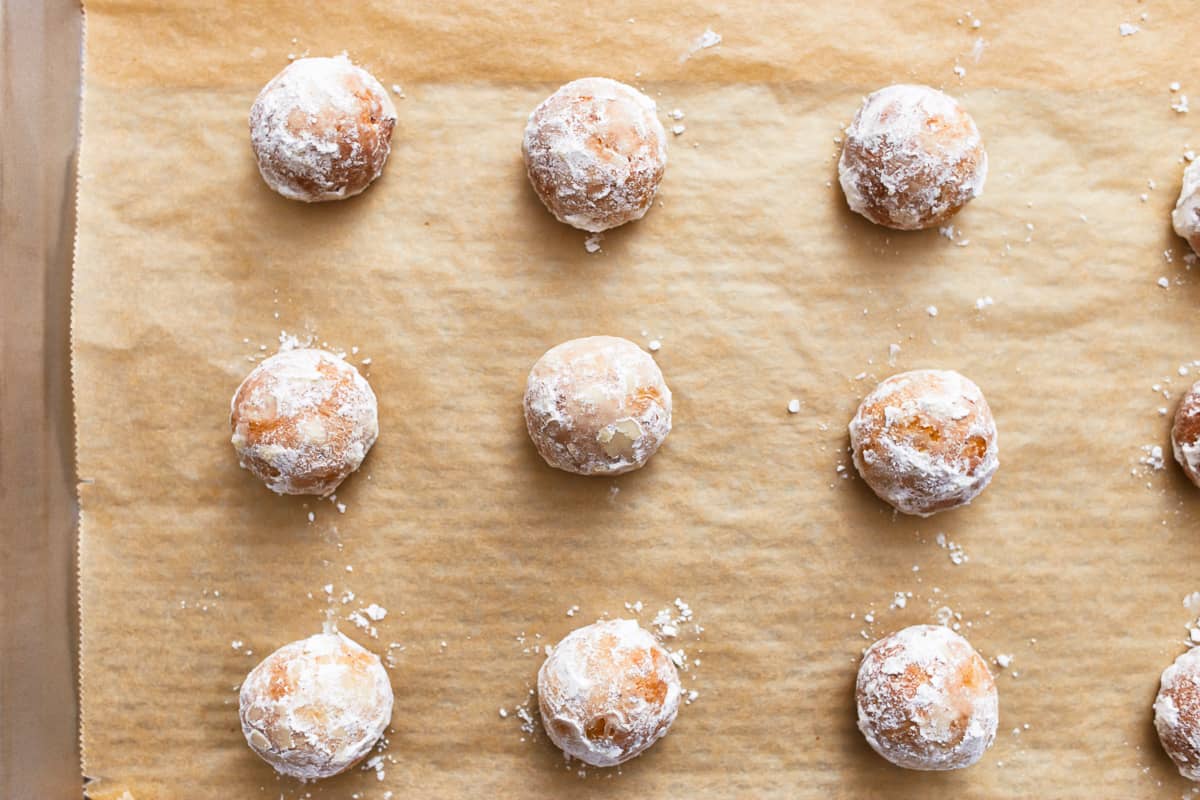 cookies coated in powdered sugar on a baking sheet.