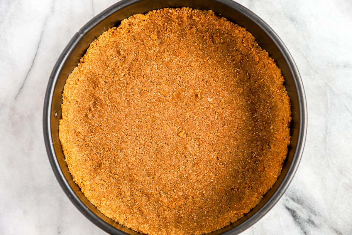 Crust mixture pressed into the bottom of a springform pan.