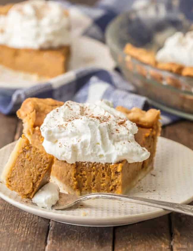 A slice of "pumpkin pie" on a plate with whipped cream.