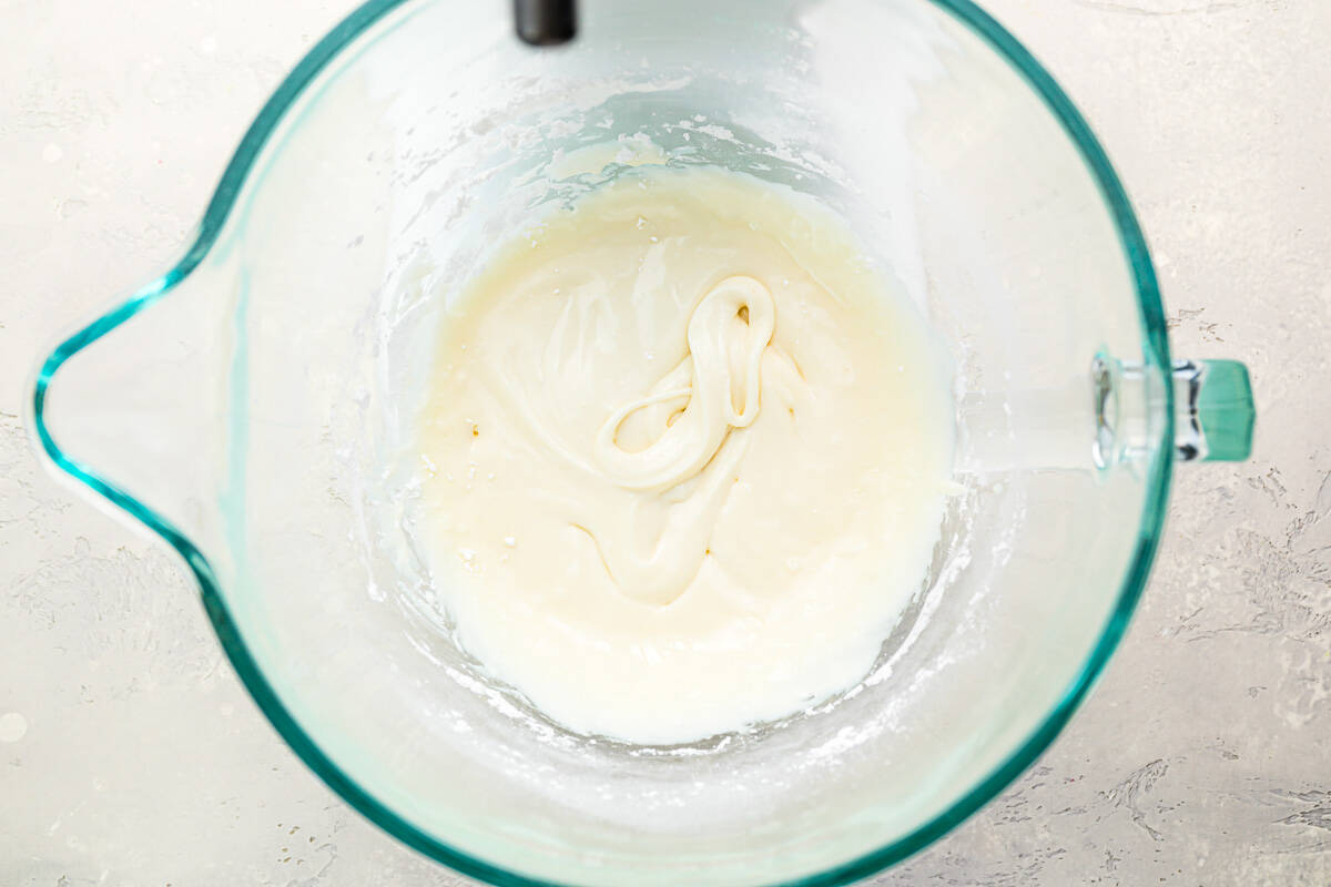 A glass bowl with icing in it.