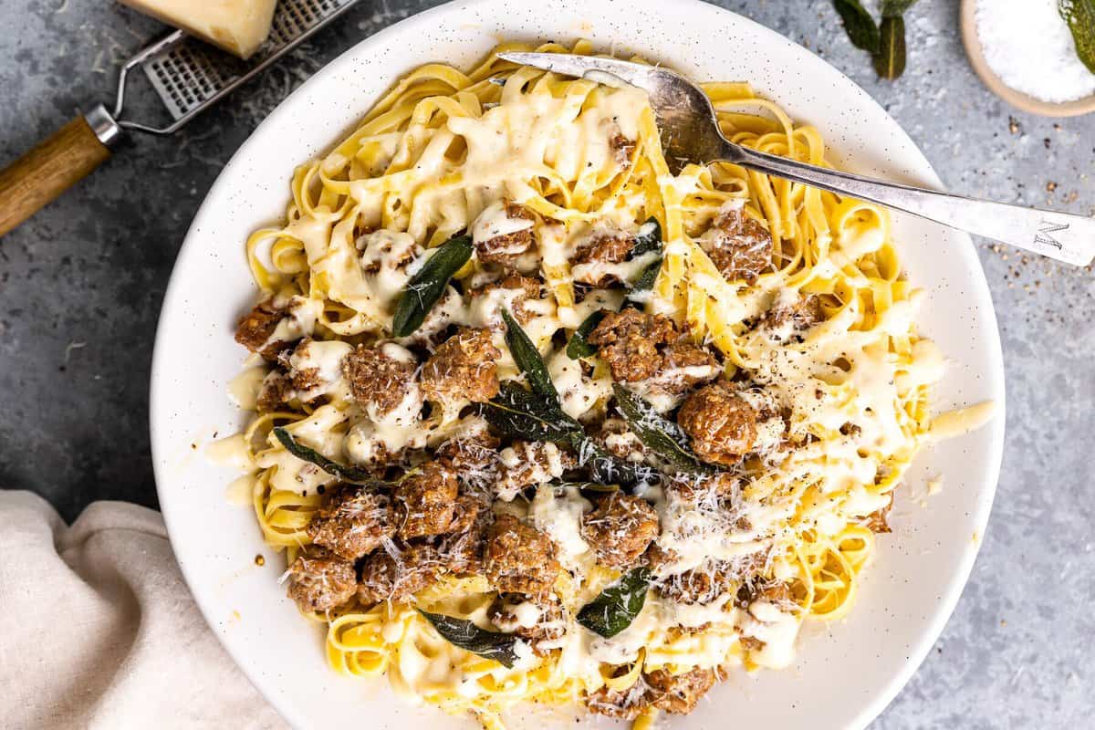 overhead view of fettuccini alfredo on a white plate with a fork.