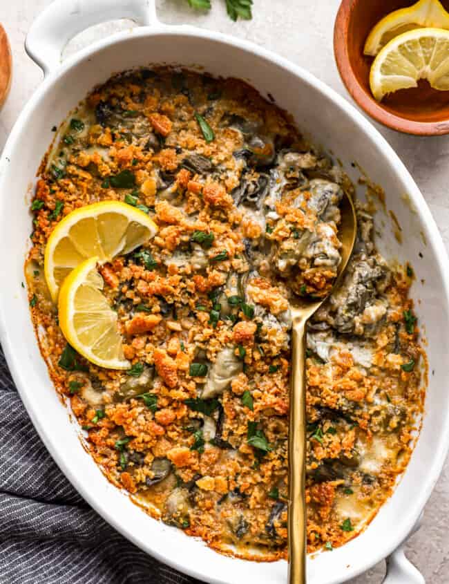 A dish of spinach and artichoke dip with a spoon.