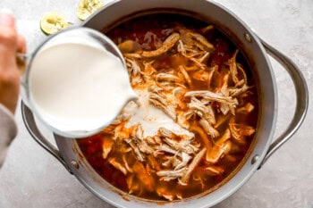 heavy cream added to chicken tortilla soup in a dutch oven.