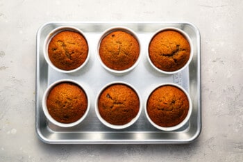 6 baked puddings on a baking sheet.