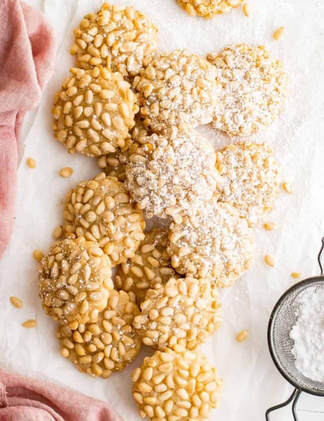 overhead image of pignoli cookies with a dusting of powdered sugar