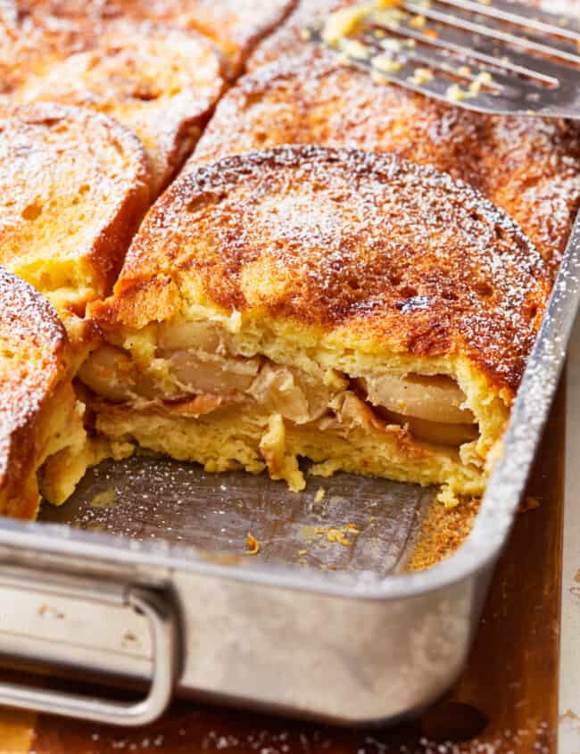 An apple french toast casserole in a pan with a fork.