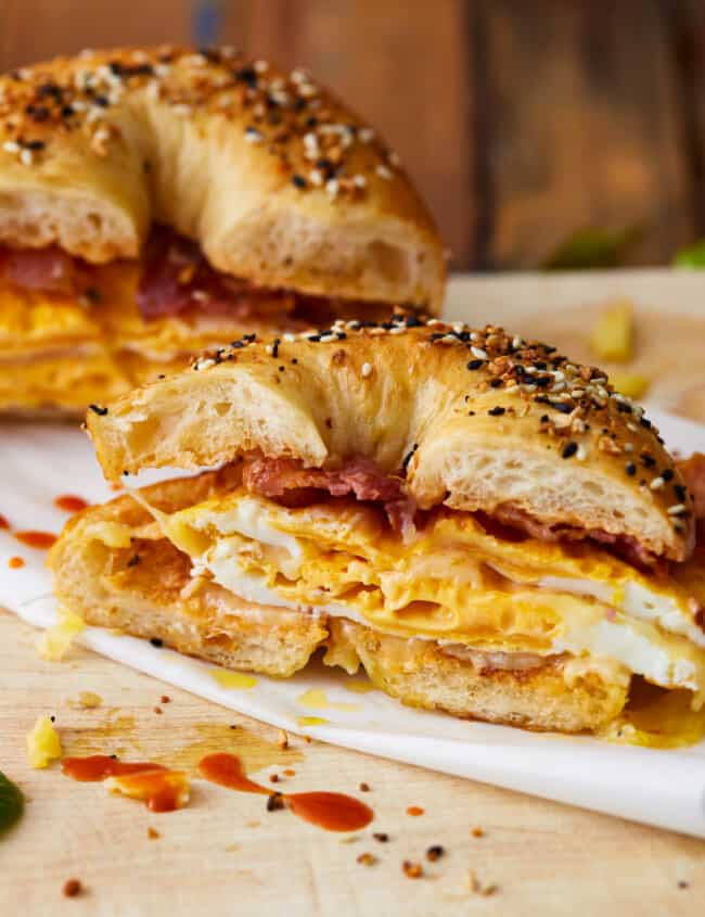 A bagel breakfast sandwich with eggs and bacon on it.