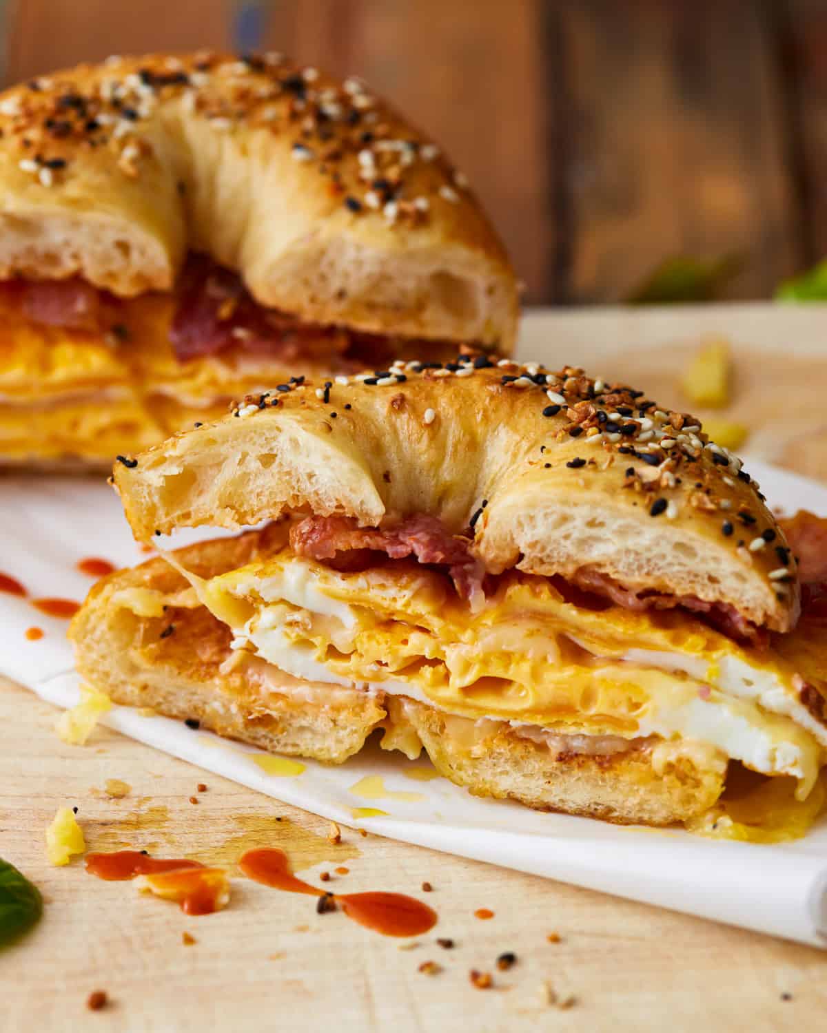 A bagel breakfast sandwich with eggs, cheese, and bacon on it.