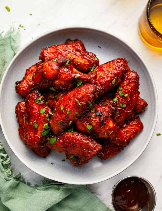 BBQ chicken wings served on a white plate.