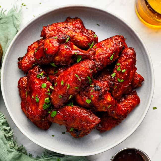 Plate of bbq chicken wings with a glass of beer.