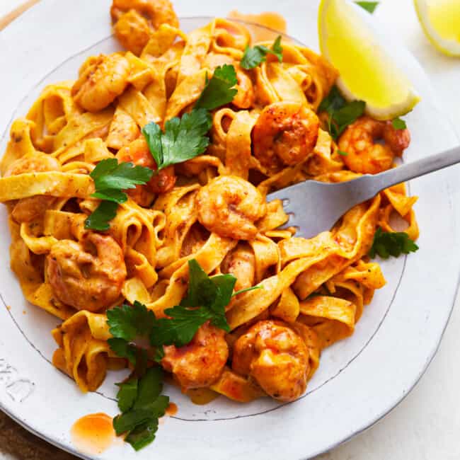 A plate of blackened shrimp alfredo pasta.