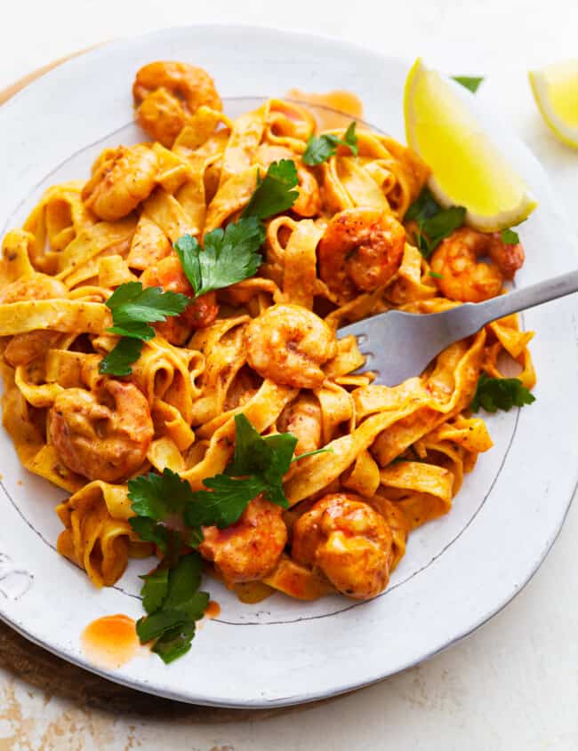 A plate of blackened shrimp alfredo pasta.