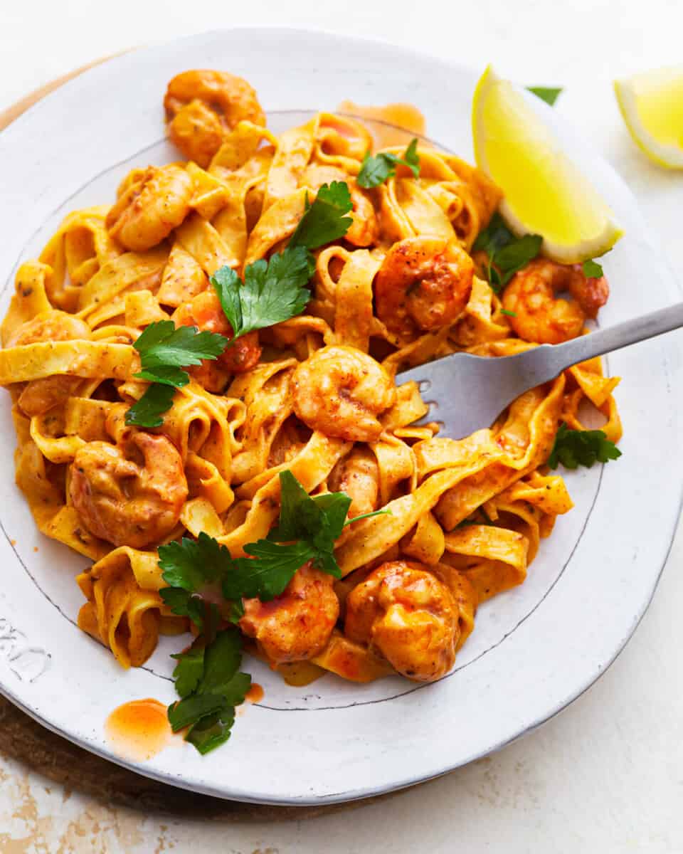 A plate of blackened shrimp alfredo pasta.