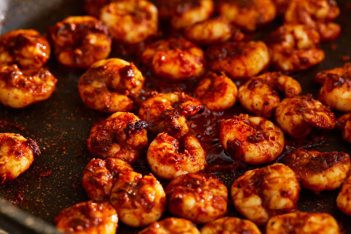 Seasoned blackened shrimp cooking in a pan.