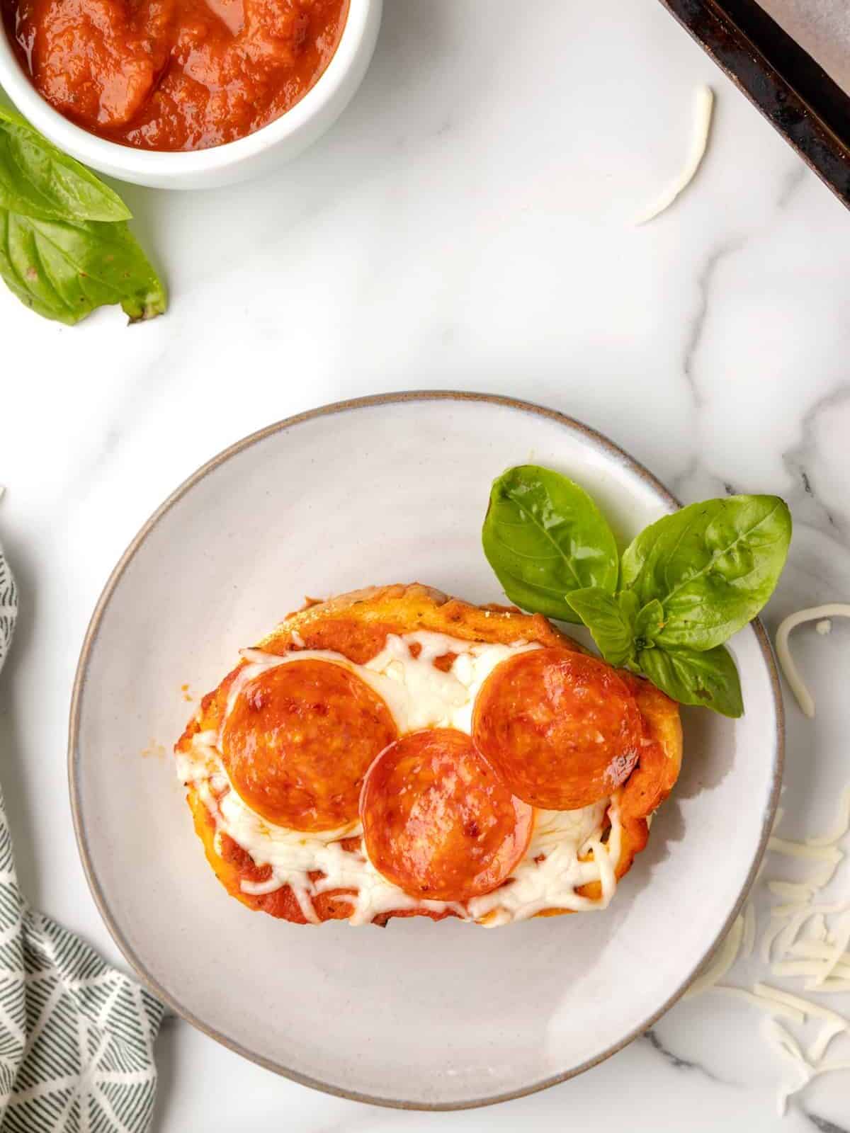 overhead view of a slice of texas toast pizza on a white plate.